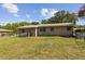 View of the back of the home and the spacious backyard enclosed with a chain-link fence at 146 Mills Rd, Deland, FL 32724