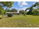 View of the back of the home and the backyard enclosed with a chain-link fence at 146 Mills Rd, Deland, FL 32724