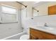 Bright bathroom with a tub and shower combination, white tile, and simple vanity at 146 Mills Rd, Deland, FL 32724