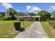 View of a single story home with a brick facade and long driveway at 146 Mills Rd, Deland, FL 32724