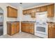 Traditional kitchen featuring tan cabinets, tile floors, and white electric range at 146 Mills Rd, Deland, FL 32724