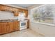 Bright kitchen featuring tan cabinets, tile floors, white appliances, and a window at 146 Mills Rd, Deland, FL 32724