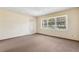 Living room featuring neutral walls, carpet flooring, a front door, and a large window at 146 Mills Rd, Deland, FL 32724