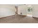 Spacious living room with neutral walls, carpet flooring, and an arched doorway to a sunroom at 146 Mills Rd, Deland, FL 32724