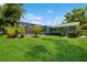 Expansive backyard view with a screened-in pool area and mature trees, perfect for outdoor enjoyment at 1639 Choctaw Trl, Maitland, FL 32751