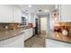 Kitchen with stainless steel appliances, stone countertops, stone tile floors, and white cabinetry at 1639 Choctaw Trl, Maitland, FL 32751