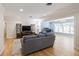 Open-concept living room featuring wood floors, a comfortable gray sofa, and a view into the sunroom at 1639 Choctaw Trl, Maitland, FL 32751