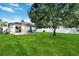 Spacious backyard features green grass, a large tree, and a patio with a sliding glass door at 16603 Corner Lake Dr, Orlando, FL 32820