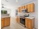 Bright, wooden kitchen cabinets and stainless steel appliances are highlights of this home at 16603 Corner Lake Dr, Orlando, FL 32820