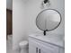 White bathroom vanity with round mirror and sleek black faucet at 1868 14Th St, Orange City, FL 32763