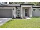 Close up of the front door and two car garage of this single-story gray house at 1868 14Th St, Orange City, FL 32763