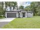 Charming one-story home featuring a gray exterior, dark roof, well-manicured lawn and two car garage at 1868 14Th St, Orange City, FL 32763