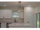 Bright kitchen showcasing a stylish light fixture, stainless appliances, and white cabinetry at 1868 14Th St, Orange City, FL 32763