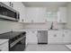Well-lit kitchen showcasing white cabinets, quartz counters, stainless steel appliances, and modern design at 1868 14Th St, Orange City, FL 32763