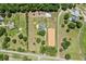 Aerial view of the property featuring a house, barn, pool, and horse arena at 19630 County Road 455, Clermont, FL 34715