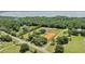 The property features multiple buildings, a large training arena, lush trees, and a lake in the distance at 19630 County Road 455, Clermont, FL 34715