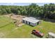 Aerial view of a barn, fenced pastures, and a parked truck on a sunny day at 19630 County Road 455, Clermont, FL 34715