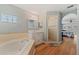 Bathroom showcases a soaking tub, vanity with marble countertop, and glass-enclosed shower, perfect for relaxation at 19630 County Road 455, Clermont, FL 34715