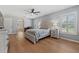 Bright bedroom features hardwood floors, a ceiling fan, and shuttered windows offering natural light and outdoor views at 19630 County Road 455, Clermont, FL 34715