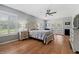 Spacious bedroom with hardwood floors, shuttered windows, a ceiling fan, and access to a private outdoor space at 19630 County Road 455, Clermont, FL 34715