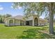 Charming home features a well-manicured lawn, circular windows, and a screened entryway at 19630 County Road 455, Clermont, FL 34715
