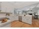 An open-concept kitchen features wood floors and white cabinetry with stainless appliances at 19630 County Road 455, Clermont, FL 34715