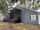 Backyard view of a home featuring a screened-in porch and a well-maintained yard at 2061 Piedmont Park Blvd, Apopka, FL 32703