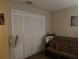 Bedroom showcasing a closet with folding doors and a cozy futon seating area, great for relaxing at 2061 Piedmont Park Blvd, Apopka, FL 32703