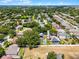 A wide aerial shot showing a well-maintained community with mature trees, ponds, and homes with private pools at 207 Via Tuscany Loop, Lake Mary, FL 32746