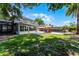 Expansive backyard featuring a sunroom, lush lawn, pool with fence, and patio area for entertaining at 207 Via Tuscany Loop, Lake Mary, FL 32746