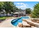 Backyard paradise featuring a pool with a waterfall, lush landscaping, a patio, and a safety fence at 207 Via Tuscany Loop, Lake Mary, FL 32746