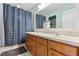 Bright bathroom featuring a double sink vanity, white countertops, and a blue patterned shower curtain at 207 Via Tuscany Loop, Lake Mary, FL 32746