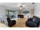 Bright living room features hardwood floors, ceiling fan, TV, and sliding glass doors to the lanai at 207 Via Tuscany Loop, Lake Mary, FL 32746