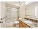 Bathroom featuring a shower-tub combo with glass door, and granite vanity, creating a functional space at 241 Ruth Blvd, Longwood, FL 32750