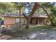 Single-story home with covered porch, screen door, mature landscaping, and large trees at 241 Ruth Blvd, Longwood, FL 32750