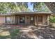 Single-story home with covered porch, screen door, mature landscaping, and large trees at 241 Ruth Blvd, Longwood, FL 32750