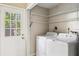 Functional laundry room with washer, dryer, and storage shelves, making chores convenient at 241 Ruth Blvd, Longwood, FL 32750