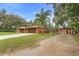 Exterior shot of home with large driveway and garage and additional outbuilding with paddock at 2678 Wilmhurst Rd, Deland, FL 32720