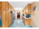 Galley kitchen features oak cabinets, stainless steel appliances, and blue tile floors at 2678 Wilmhurst Rd, Deland, FL 32720