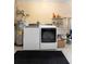 Laundry room featuring washer, dryer, water heater, shelving, utility sink, and dark gray rug at 2678 Wilmhurst Rd, Deland, FL 32720