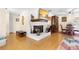 Cozy living room features a white brick fireplace and hardwood floors at 2678 Wilmhurst Rd, Deland, FL 32720