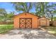 Exterior view of outbuildings on the property with grass and mature trees at 2678 Wilmhurst Rd, Deland, FL 32720