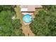 Aerial view of a backyard pool area with patio and lush landscaping surrounding at 2678 Wilmhurst Rd, Deland, FL 32720
