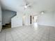 Bright living room featuring tile floors, two ceiling fans, and staircase access to upper level at 3247 Forest Oaks Ct # 116, Winter Park, FL 32792