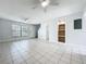 Open-concept living area with tile flooring, a built-in shelving unit, and ample natural light at 3247 Forest Oaks Ct # 116, Winter Park, FL 32792