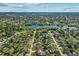 An aerial view showcases a well-planned neighborhood with homes nestled among mature trees, a nearby lake, and green spaces at 3256 Amber St, Deltona, FL 32738