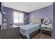 Calm bedroom featuring a padded headboard bed, purple textured walls, and a vanity table for a peaceful retreat at 3256 Amber St, Deltona, FL 32738