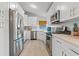A bright kitchen features white cabinetry, stainless appliances and modern finishes at 3256 Amber St, Deltona, FL 32738