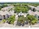 Aerial view of community entrance, colorful townhomes, mature landscaping, and gatehouse at 3280 Soho St # 306, Orlando, FL 32835