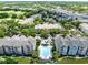Aerial view of a community with a central pool, colorful townhomes, and mature trees at 3280 Soho St # 306, Orlando, FL 32835
